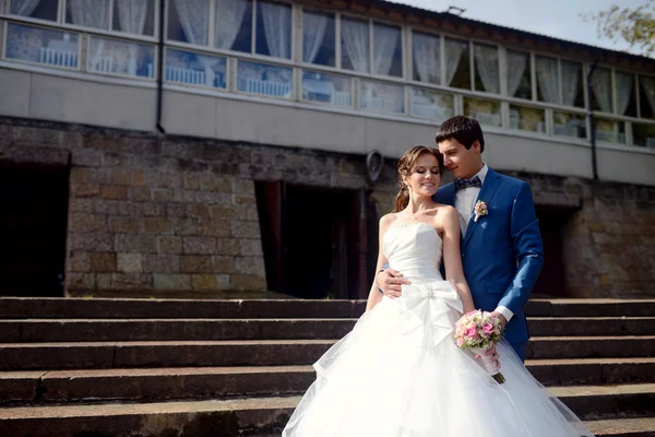 Bruid en bruidegom knuffelen op trappen — Stockfoto