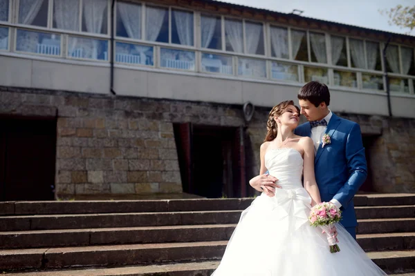 Bruid en bruidegom knuffelen op trappen — Stockfoto