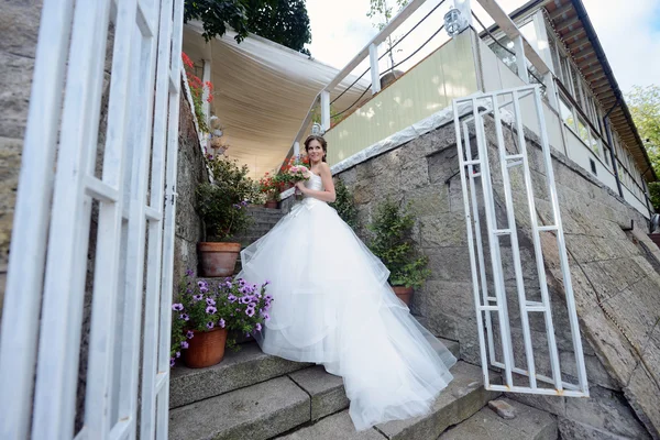 Bela noiva em vestido de noiva com buquê — Fotografia de Stock