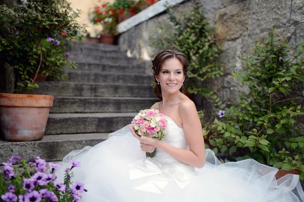 Bella sposa in abito da sposa con bouquet — Foto Stock