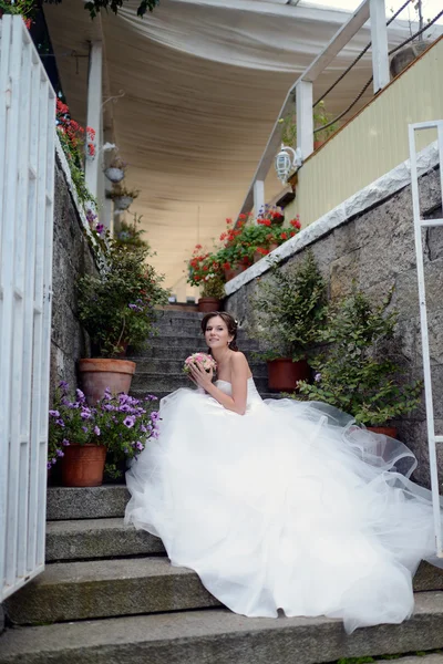 Bella sposa in abito da sposa con bouquet — Foto Stock