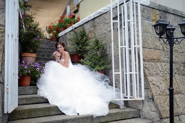 Bella sposa in abito da sposa con bouquet — Foto Stock