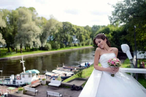 Bella sposa in abito da sposa con bouquet — Foto Stock