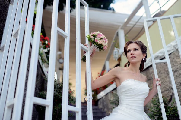 Krásná nevěsta ve svatebních šatech s kyticí — Stock fotografie