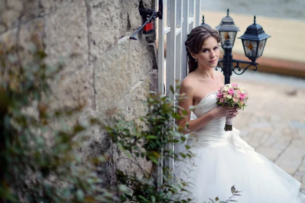 Красивая невеста в свадебном платье с букетом — стоковое фото