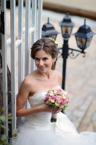 Hermosa novia en vestido de novia con ramo —  Fotos de Stock