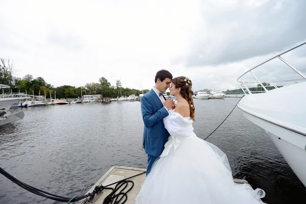 Hochzeitspaar umarmt sich auf Holzsteg — Stockfoto