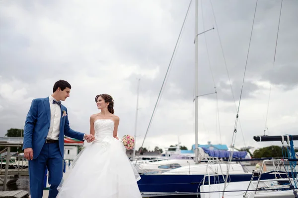 Beautiful wedding couple near boats — Stock Photo, Image
