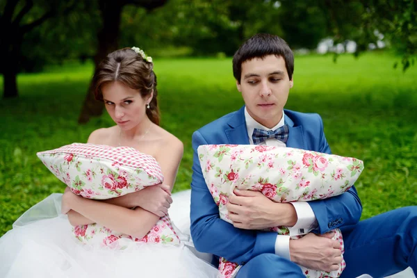 Γαμήλιο ζεύγος στο πάρκο κρατώντας μαξιλάρια — Φωτογραφία Αρχείου