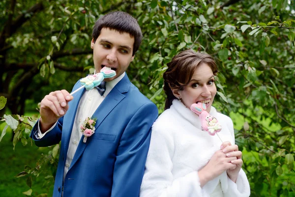 Wedding couple holding funny candies — Stock Photo, Image