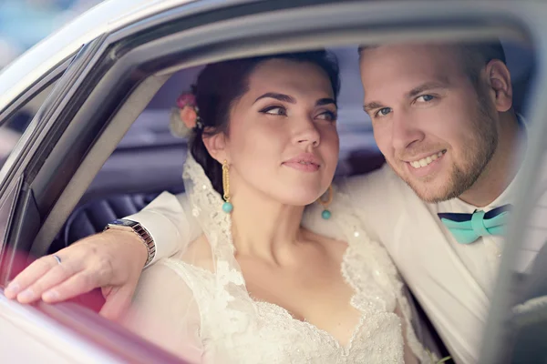 Wedding couple hugging in car — Stock Photo, Image