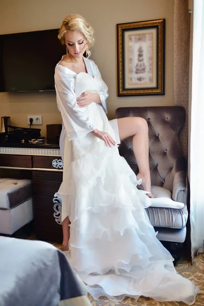 Schöne Braut beobachtet Hochzeitskleid — Stockfoto
