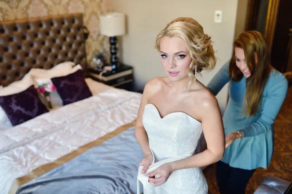 Brautjungfer schnürt Brautkleid für Braut — Stockfoto