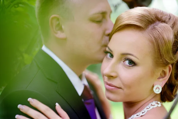 Beautiful wedding couple hugging in park — Stock Photo, Image