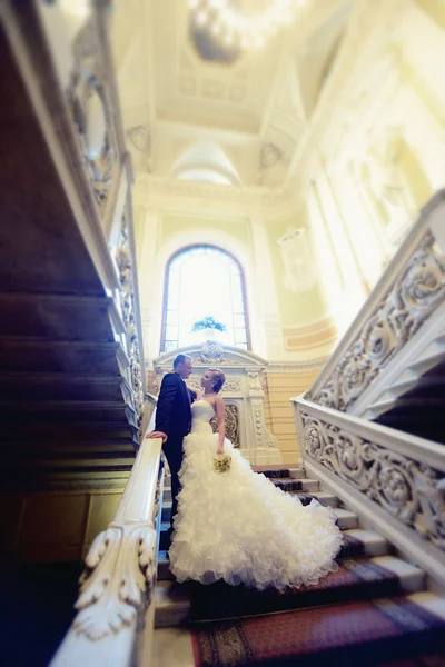 Schönes Hochzeitspaar umarmt sich auf der Treppe — Stockfoto