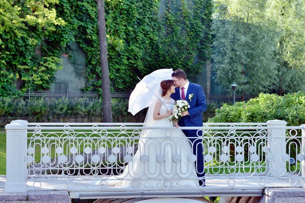 Hochzeitspaar umarmt sich auf Brücke — Stockfoto