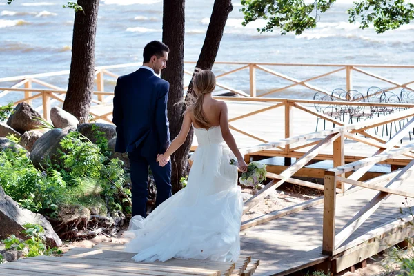 Casamento casal andando perto do mar — Fotografia de Stock