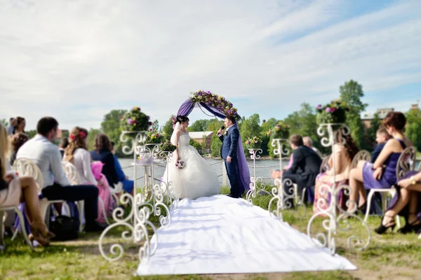 Bruid met de bruidegom op huwelijksboog — Stockfoto