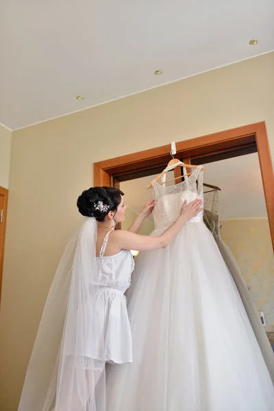 Bella sposa guardando abito da sposa — Foto Stock