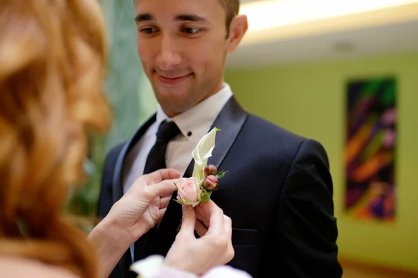 Bruden bærer boutonniere på brudgom – stockfoto