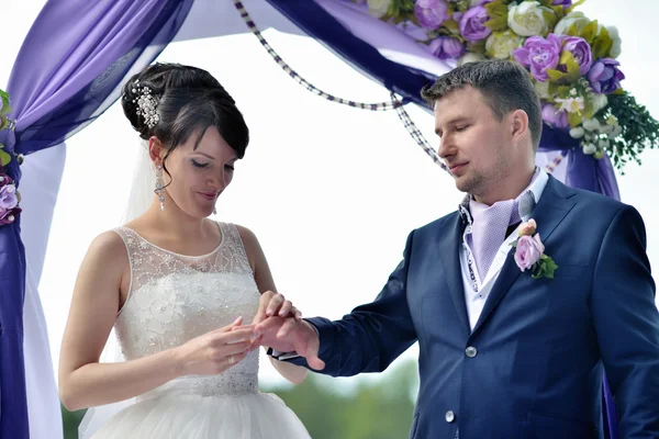 Brud med brudgummen på bröllop arch — Stockfoto