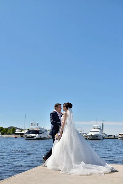 Braut mit Bräutigam am Pier am Fluss — Stockfoto