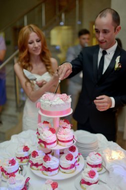 Gelin ve damat düğün pastasını kesiyor