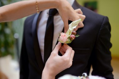 Gelin Damat üzerinde yaka çiçeği giyiyor 