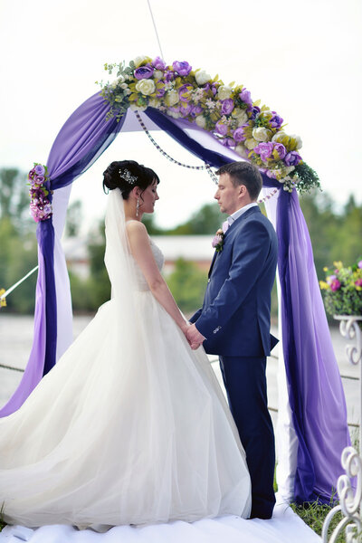 bride with groom at wedding arch