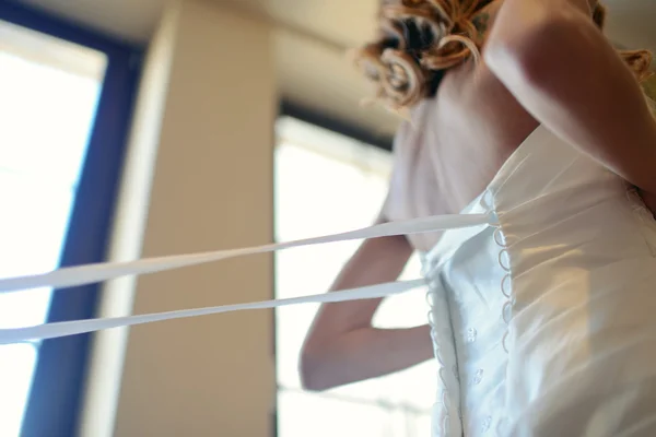 Demoiselle d'honneur est laçage robe de mariée — Photo