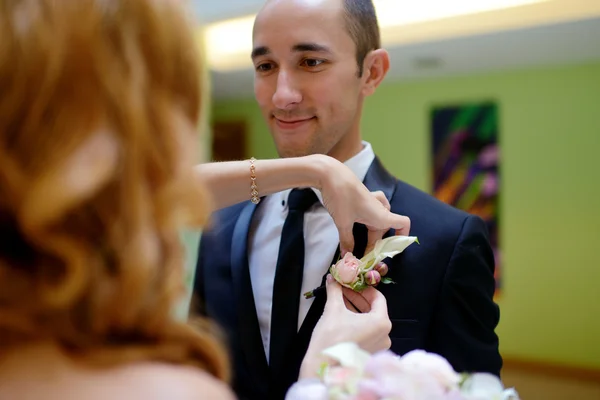 Nevěsta má na sobě boutonniere na ženicha — Stock fotografie