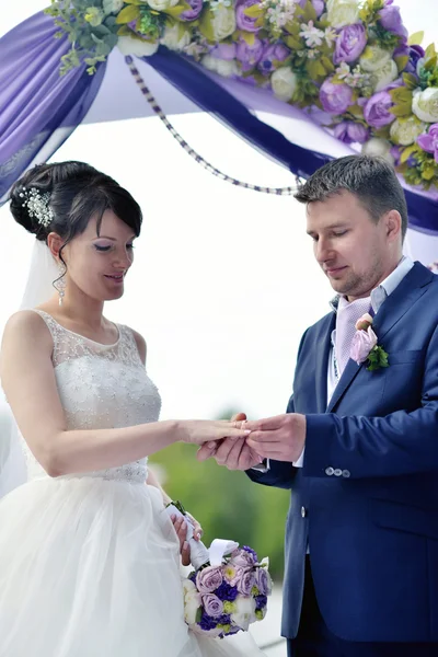 Brud med brudgummen på bröllop arch — Stockfoto
