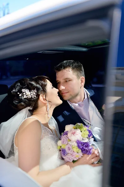 Bruidspaar knuffelen in auto — Stockfoto