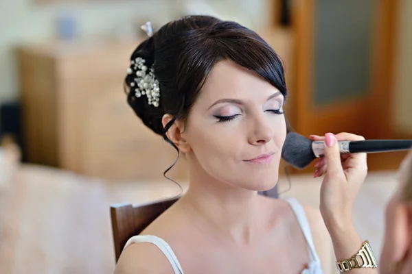 Artist making up for bride — стоковое фото