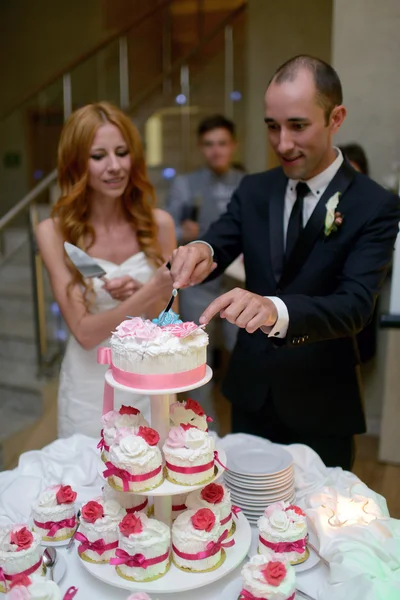 Bruid en bruidegom snijden bruidstaart — Stockfoto