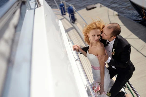 Весільна пара обіймає яхту — стокове фото