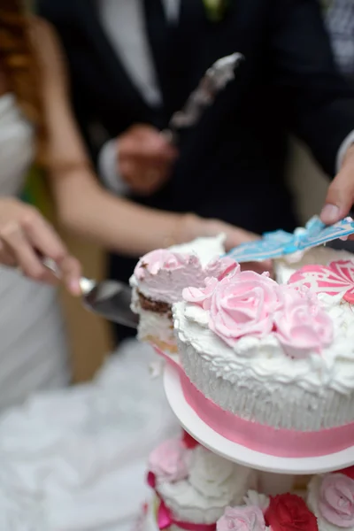 Braut und Bräutigam schneiden Kuchen an Stockfoto