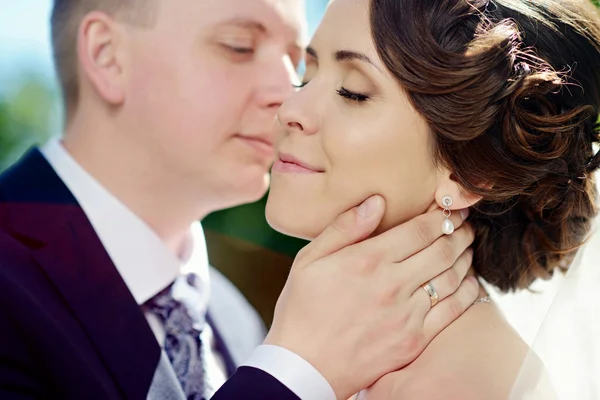 Hochzeitspaar umarmt und küsst sich — Stockfoto