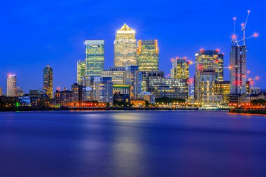 Londra 'nın doğusunda büyük bir iş bölgesi olan Canary Wharf' ta uzun süre açık alan, aydınlatılmış şehir manzarası.