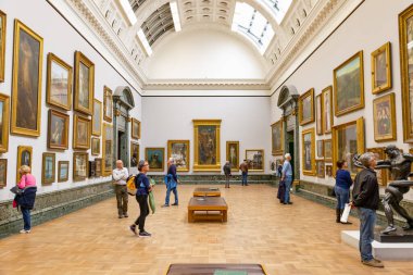 London, UK - August 15, 2019 - Interior of the museum Tate Britain with visitors looking at paintings