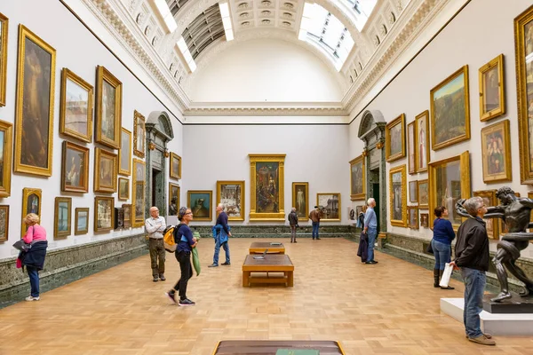 London, UK - August 15, 2019 - Interior of the museum Tate Britain with visitors looking at paintings