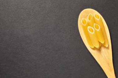 siyah bir zemin üzerine bir kaşık makarna