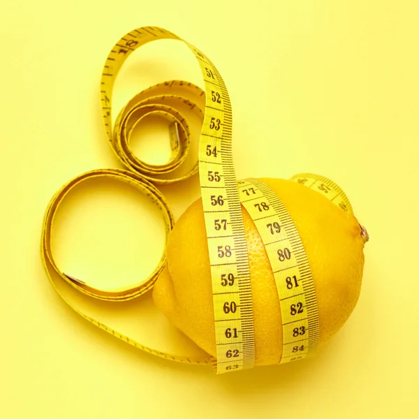 İzole limon sarı bir arka plan üzerinde bir ölçüm bandı ile — Stok fotoğraf