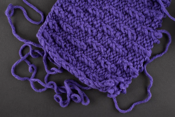 A piece of purple knitting, against a dark background — Stock Photo, Image
