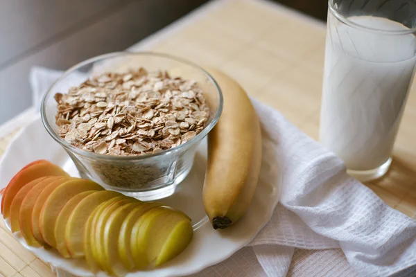 Śniadanie. Płatki owsiane z mlekiem, banan, jabłko i cytryny — Zdjęcie stockowe