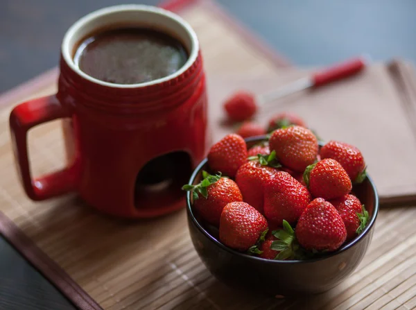 Επιδόρπιο. Fondue σοκολάτας σε ένα ερυθρό Κύπελλο με ώριμα, φωτεινό φράουλες σε φόντο ξύλινη — Φωτογραφία Αρχείου