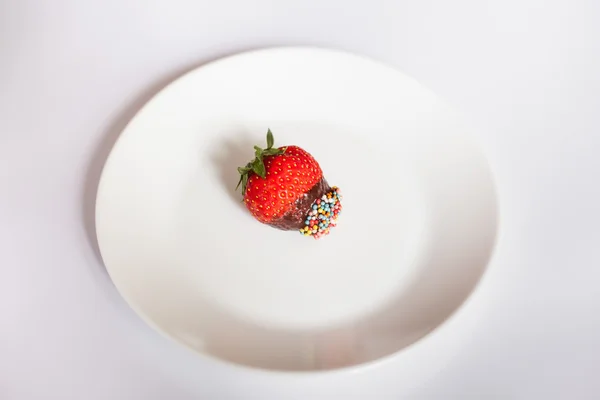 Chocolade dessert met verse en geurige aardbeien bezaaid met gekleurde suiker zoetigheden — Stockfoto