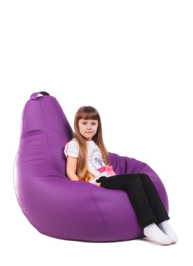 Cushioned furniture. A child with toys and books on a chair bag clipart