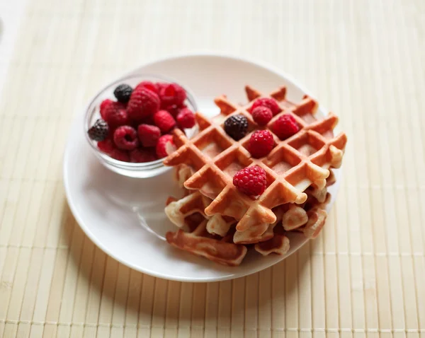 Waffles com mel, geléia e bagas em um prato branco, em vista de perto — Fotografia de Stock