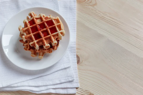 Gofres con miel, mermelada y bayas en un plato blanco, a primera vista — Foto de Stock